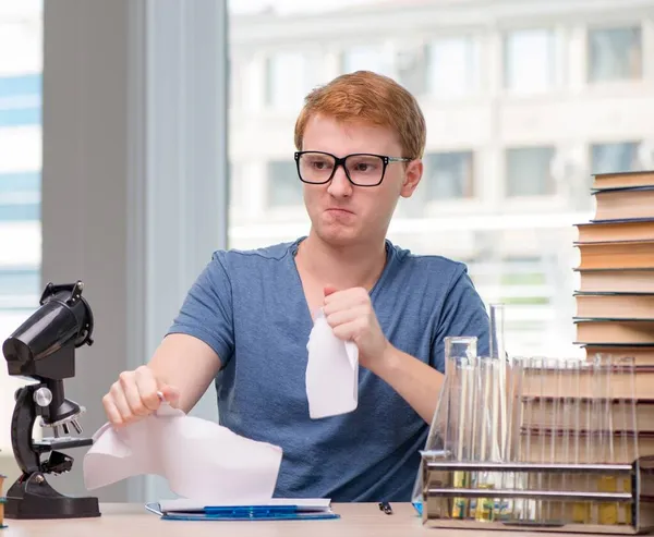 Jovem estudante cansado e exausto se preparando para o exame de química — Fotografia de Stock