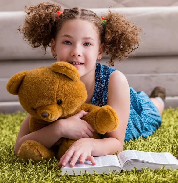 Klein mooi meisje die thuis boeken leest — Stockfoto