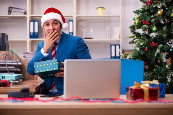 Młody pracownik świętuje Boże Narodzenie w miejscu pracy — Zdjęcie stockowe