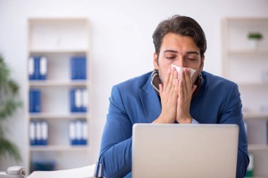 İş yerinde acı çeken genç bir erkek işçi.