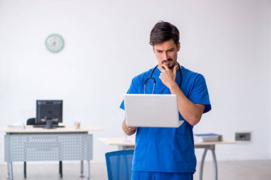 Klinikte çalışan genç erkek doktor.