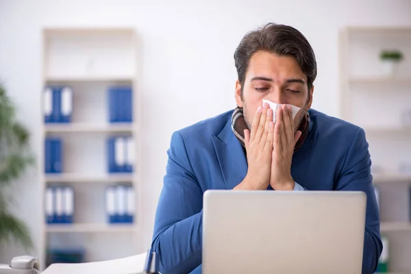 Giovane dipendente maschile che soffre sul posto di lavoro — Foto Stock