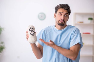 Pahalı ilaç konseptinde genç bir erkek hasta.