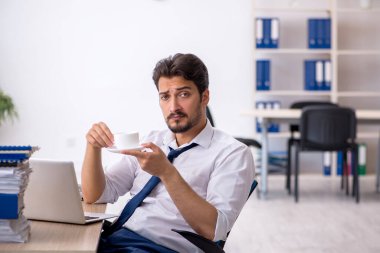 Molada kahve içen genç bir erkek.