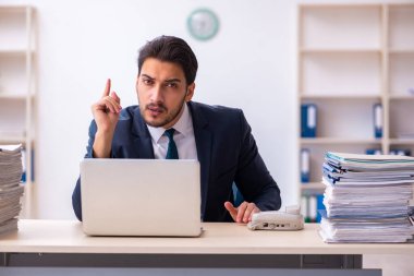 Genç işadamı ve ofiste çok fazla iş var.
