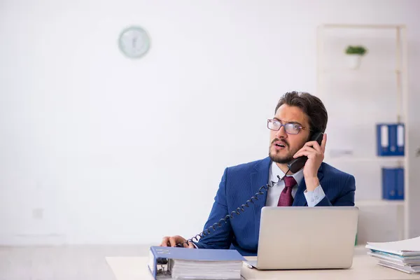 Empleado joven sentado en el lugar de trabajo — Foto de Stock