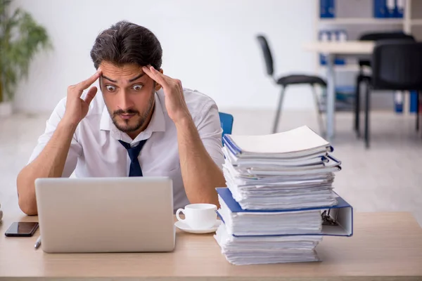 Giovane dipendente maschio infelice con un lavoro eccessivo in ufficio — Foto Stock