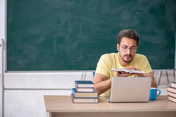 Joven estudiante masculino preparándose para los exámenes en el aula — Foto de Stock