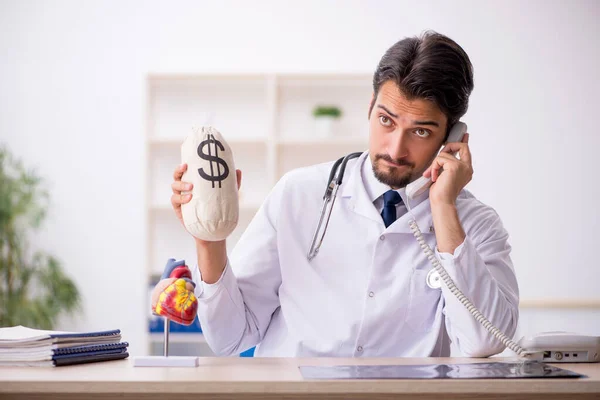 Jovem médico cardiologista segurando monebag — Fotografia de Stock