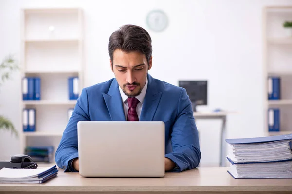 Jovem funcionário masculino infeliz com excesso de trabalho no escritório — Fotografia de Stock