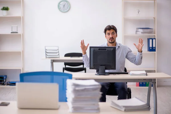 Giovane dipendente maschio e troppo lavoro in ufficio — Foto Stock