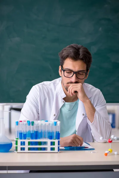 Jonge mannelijke chemicus voor schoolbord — Stockfoto