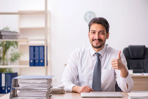 Joven empleado masculino y demasiado trabajo en la oficina —  Fotos de Stock