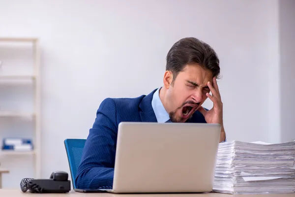 Empleado joven de negocios y demasiado trabajo en la oficina —  Fotos de Stock