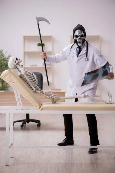 Diablo médico radiólogo examinando esqueleto paciente —  Fotos de Stock