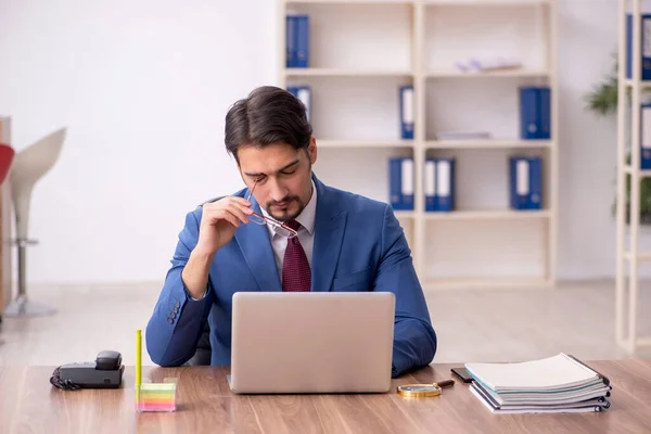 Empleado joven sentado en el lugar de trabajo — Foto de Stock