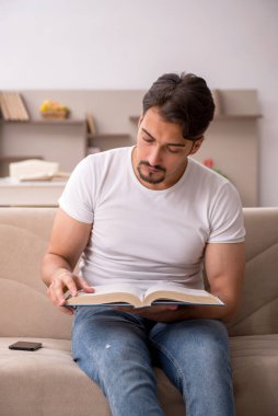 Genç erkek öğrenci salgın sırasında evde çalışıyor.