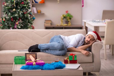 Genç adam Noel 'i evde yalnız kutluyor.