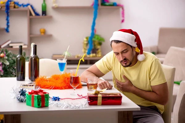 Młody mężczyzna sprząta mieszkanie po przyjęciu świątecznym — Zdjęcie stockowe