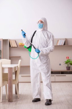 Young male contractor disinfecting at home