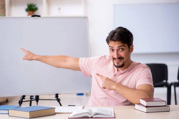 Ung mannlig lærer i klasserommet under pandemi – stockfoto