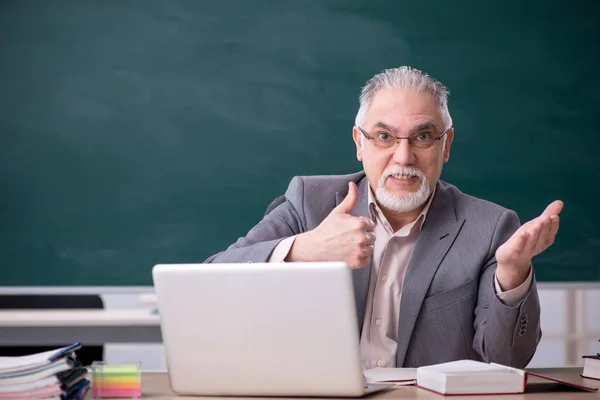 Oude mannelijke leraar voor schoolbord — Stockfoto