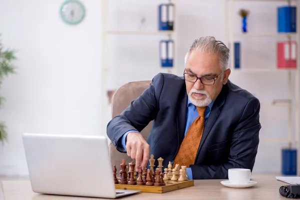 Starý podnikatel hraje šachy na pracovišti — Stock fotografie