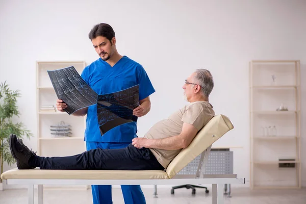 Vecchio paziente maschio visting giovane medico radiologo maschile — Foto Stock