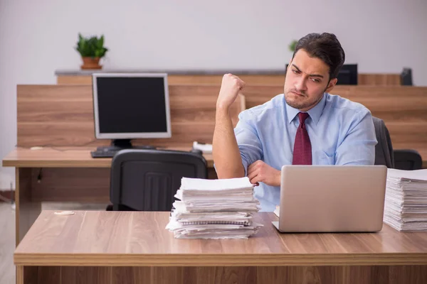 Joven empleado masculino descontento con el trabajo excesivo en la oficina —  Fotos de Stock