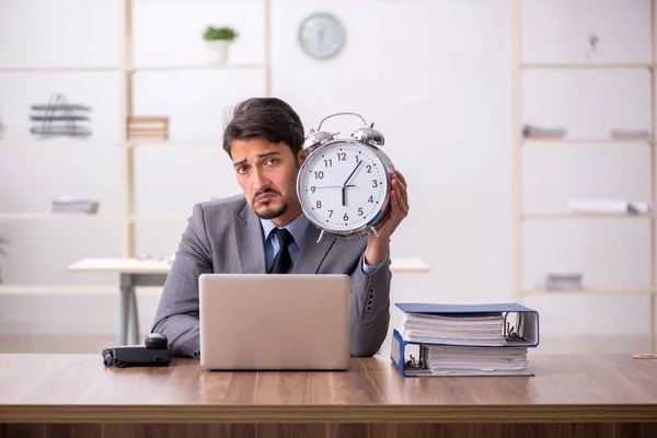 Joven empleado masculino en concepto de gestión del tiempo —  Fotos de Stock