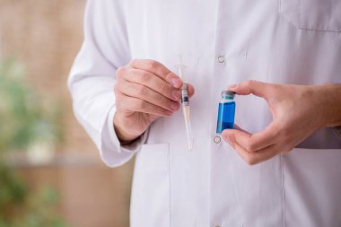 Aşı konseptinde genç bir erkek doktor.