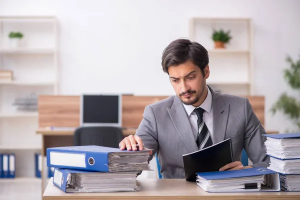 Jovem funcionário masculino infeliz com excesso de trabalho no escritório — Fotografia de Stock