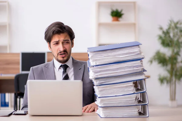 Jovem funcionário masculino infeliz com excesso de trabalho no escritório — Fotografia de Stock