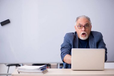 Tele-eğitim konseptinde yaşlı bir erkek öğretmen