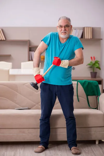 Oude man doet sanitair thuis — Stockfoto