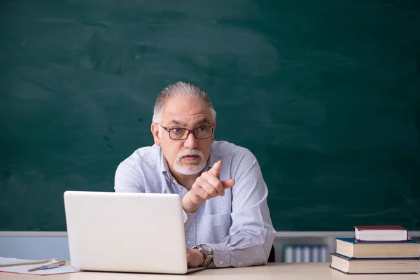Starý učitel samec před zelenou tabulí — Stock fotografie