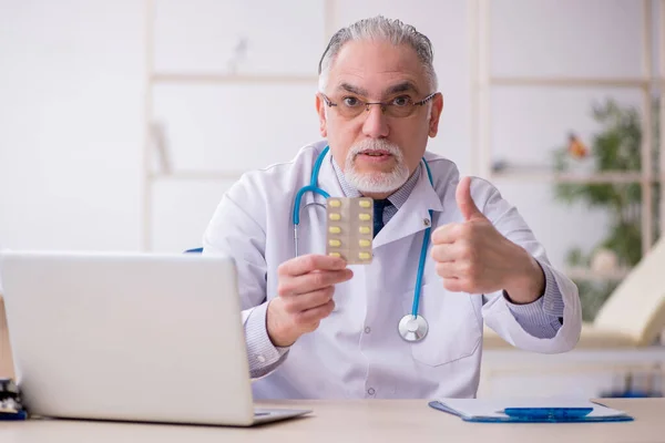 Klinikte çalışan yaşlı erkek doktor. — Stok fotoğraf