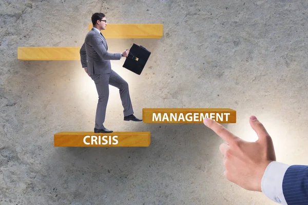 Crisis management concept with climbing businessman — Stock Photo, Image