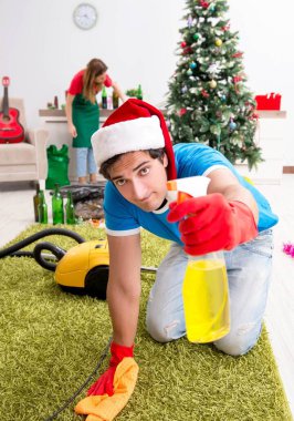 Noel partisinden sonra genç bir aile evi temizliyor.