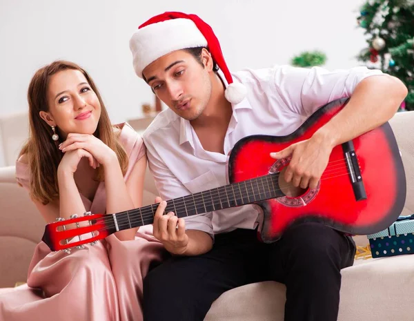 Junges Paar spielt zu Weihnachten Gitarre — Stockfoto