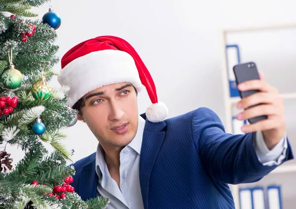 Young employee celebrating christmas at workplace — Stock Photo, Image
