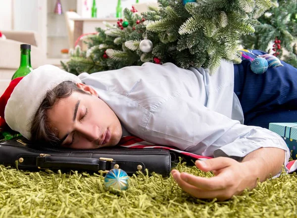 Young handsome employee celebrating Christmas at workplace — Stock Photo, Image