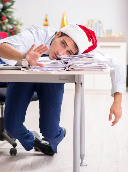 Jovem e bonito funcionário celebrando o Natal no local de trabalho — Fotografia de Stock