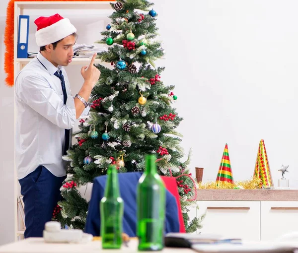Mladý pohledný zaměstnanec slaví Vánoce na pracovišti — Stock fotografie