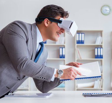 Ofiste sanal gerçeklik gözlüklü bir iş adamı var.