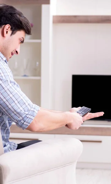 Hombre joven viendo la televisión en casa — Foto de Stock