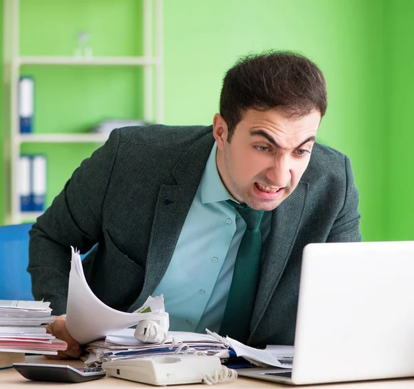 Homme d'affaires en colère contre le travail excessif assis dans le bureau — Photo