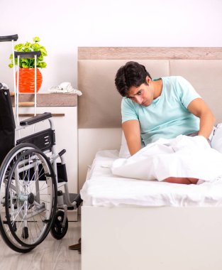 Genç yakışıklı engelli adam evde iyileşiyor.