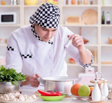 Genç aşçı mutfakta çalışıyor.