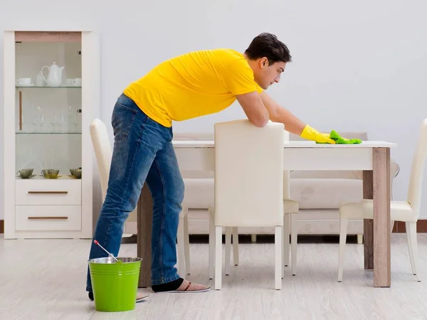 Een man die het huis schoonmaakt en zijn vrouw helpt — Stockfoto